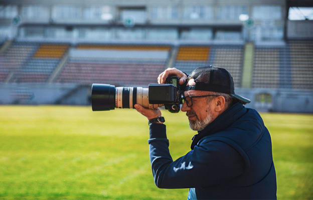 Sports Photography: Freeze the Moment, Capture the Thrill 2 A photographer works at a press conference at the stadium, photographing a politician or the owner of a football club.