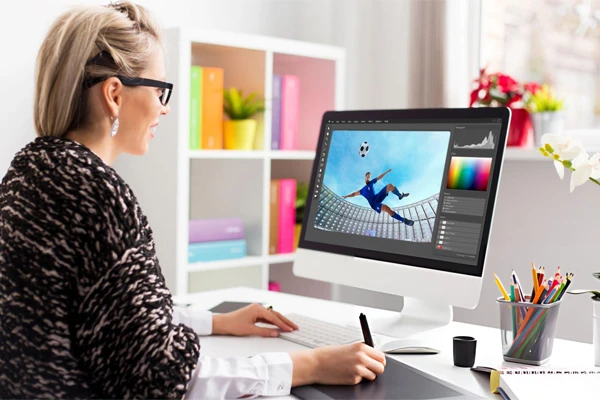 Sports Photography: Freeze the Moment, Capture the Thrill 12 Woman editing Sports photo on computer.