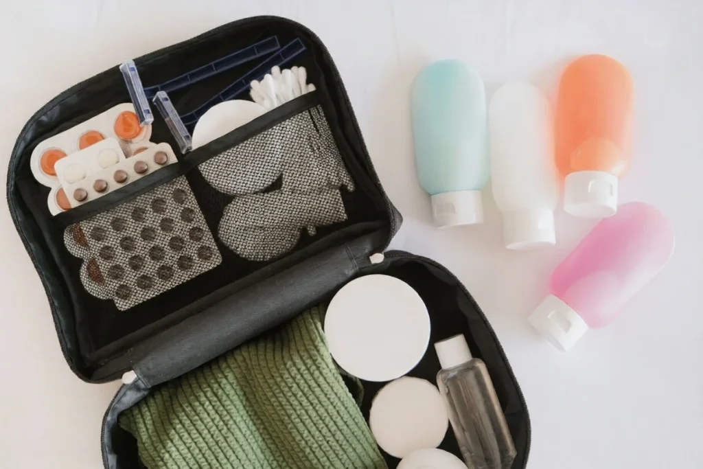 Black cosmetic travel kit on the bed. colorful cosmetic bottles, pills and hygiene items for travel