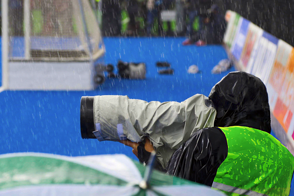 Sports Photography: Freeze the Moment, Capture the Thrill 14 17 A sports photographer at work in rain